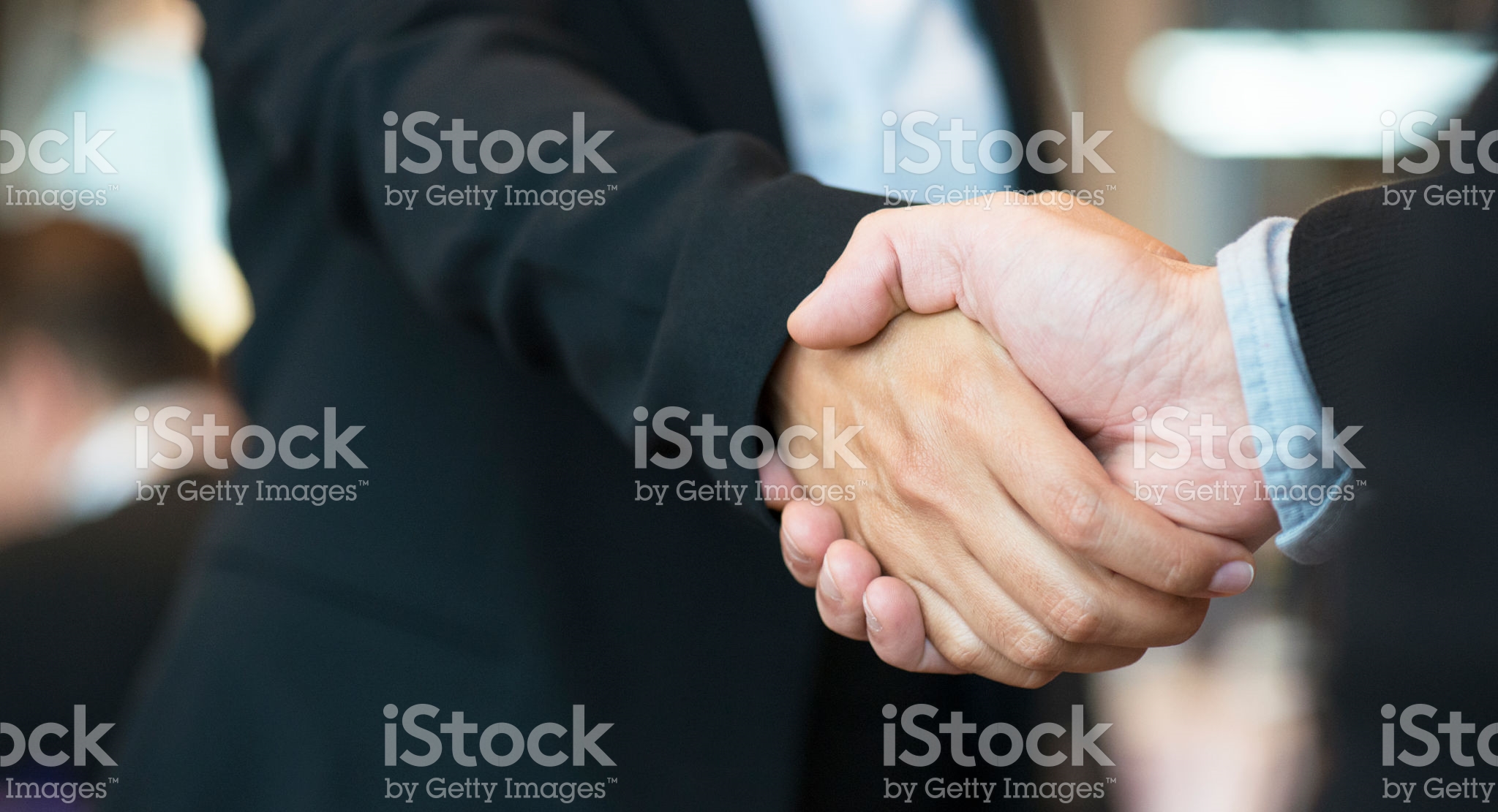 Two people shaking hands in a close up picture.